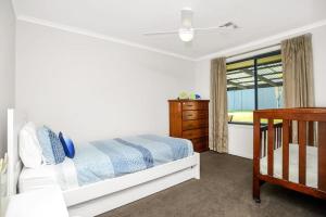 a bedroom with a bed and a dresser and a window at Family Vibes By Middleton Beach- Free Wifi in Middleton