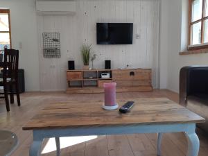a living room with a table with a remote control at Maison Casteljaloux in Heiteren