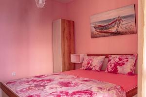 Апартамент Морски Полъх في رافدا: غرفة نوم مع سرير بجدران وردية