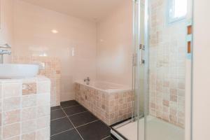 Un baño con bañera, lavabo y ducha. en Les Forges Villas - 5 room villa for 8 people, en Vasles