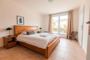 Un dormitorio con una cama grande y una ventana. en Les Forges Villas - 5 room villa for 8 people, en Vasles