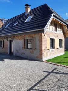 a brick house with a black roof on a driveway at Maison Casteljaloux in Heiteren