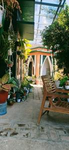 a patio with a wooden bench and potted plants at Latansa Homestay in Banyuwangi