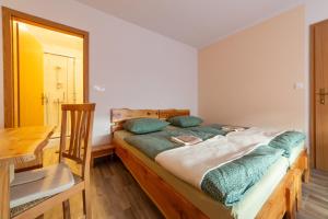a bedroom with a bed and a wooden table at Seventh house in Ilirska Bistrica