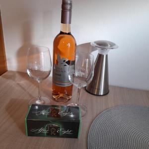 een fles wijn en twee wijnglazen op een tafel bij App Hedonist in Novigrad Istria