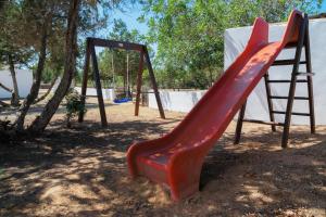 a playground with a red slide and a ladder at Ca Na Maria Teueta in San Ferrán de ses Roques