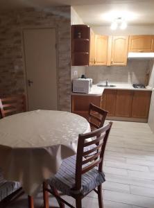 eine Küche mit einem Tisch und Stühlen sowie eine Küche mit einem Waschbecken in der Unterkunft Pákász Nyaralóház in Tiszafüred