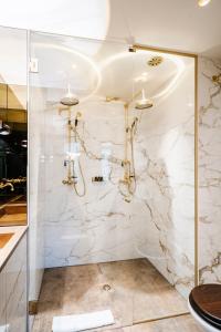 a bathroom with a shower with marble walls at Boutique Hotel The Noblemen in Amsterdam