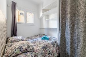 une petite chambre avec un lit et une fenêtre dans l'établissement Les pieds dans l'eau par Dodo-a-Cassis, à Cassis