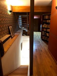 a room with a staircase with a book shelf at Gîte comme à la maison -12 pers- La Cabiote in Les Piards