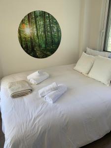 un lit blanc avec deux serviettes dessus dans l'établissement MV Penthouse, à Athènes