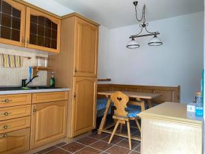 una cocina con armarios de madera y una mesa con una silla en Fam M&H Schöne 2 Zimmer Ferienwohnung in Wangen Stadtmitte, en Wangen im Allgäu