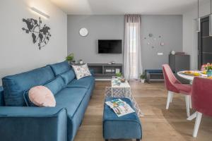 a living room with a blue couch and a table at Apartment Nina & Mauro in Poreč