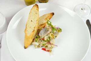 a white plate with a sandwich and a salad at Sosnowy Dworek in Borków