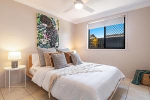 a bedroom with a large white bed with a window at Indah - Lennox Head in Lennox Head