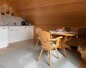 a kitchen with a table and chairs in a cabin at Ferienwohnung Lechglück in Pflach