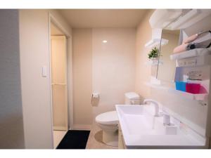 a white bathroom with a toilet and a sink at Arbor house - Vacation STAY 86735 in Kagoshima