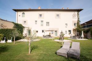 a large white building with two benches in a yard at Villa Aruch in Florence