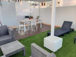 a patio with chairs and a table and a table and chairs at La Tahona de Max&jan in Conil de la Frontera