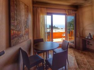 a room with a table and chairs and a balcony at Taormina Panoramic Hotel in Taormina