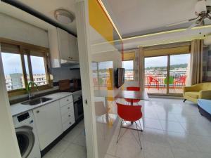 a kitchen with a table and chairs and a living room at Apartamento en Salou con las vistas al Port Aventura in Salou
