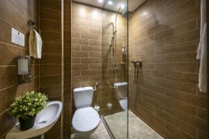 a bathroom with a toilet and a sink and a shower at Oxigén Family Hotel Noszvaj in Noszvaj +46 photos