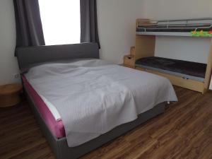 1 dormitorio con 1 cama y 1 litera con ventana en Ferienwohnung Polzer en Hörmanns bei Weitra