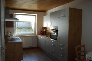 una cocina con armarios de acero inoxidable y una ventana en Ferienwohnung Polzer en Hörmanns bei Weitra