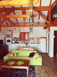 a living room with a green couch and a kitchen at Villa Magnolia in Radanovići