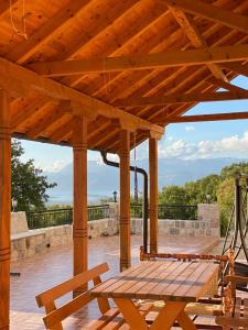 a wooden pergola with a picnic table on a deck at Villa Magnolia in Radanovići