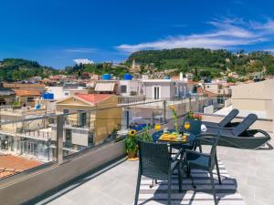 een patio met een tafel en stoelen op een balkon bij Centro Studios & Apartments in Zakynthos