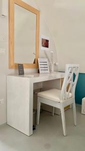 einen weißen Schreibtisch mit einem Stuhl und einem Spiegel in der Unterkunft manzoniquattro in Mottola