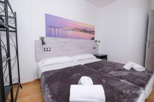 a bedroom with a large bed with two white towels at Apartamentos Ibiza in Colònia de Sant Jordi