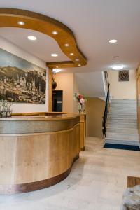 a lobby with a reception counter and stairs at Hotel Drei Kreuz in Salzburg