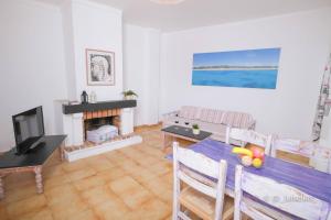 - un salon avec une table et une cheminée dans l'établissement Apartamentos Ibiza, à Colonia Sant Jordi