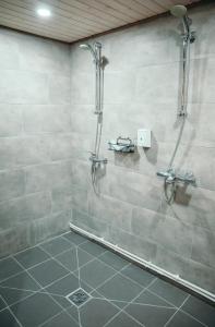 a shower stall in a bathroom with a tile floor at Гостевые дома Чекерил Village (с баней; без бани) in Petropavlovka