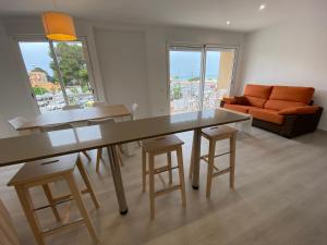 a living room with a table and chairs and a couch at Apartamento Playa I Inmomart in Peñíscola