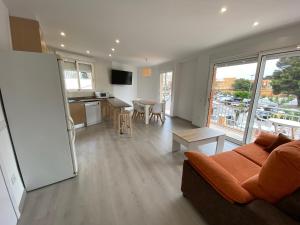 an open living room with a couch and a kitchen at Apartamento Playa I Inmomart in Peñíscola