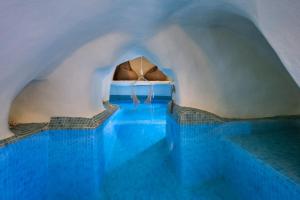 uma piscina com água azul num edifício em Mystagoge cave pool/jacuzzi, cellar and hammam em Vóthon