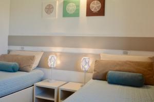 キアにあるCase Sul Mare Residenze Di Besのベッドルーム(ベッド2台、ランプ2つ付)