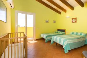 two beds in a room with yellow walls at Sa Tramuntana in Cala en Blanes +19 photos