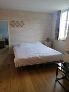 Bett in einem Zimmer mit Holzboden in der Unterkunft Côté Dyle de la Tourelle in Ways