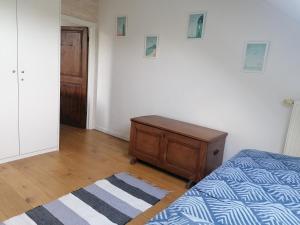 a bedroom with a bed and a dresser and a door at Côté Dyle de la Tourelle in Ways