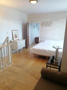 um quarto com uma cama e piso em madeira em Côté Dyle de la Tourelle em Ways