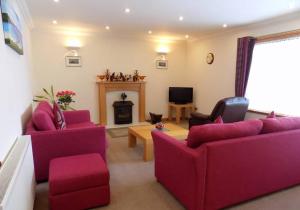 a living room with purple furniture and a fireplace at Bosta 12 Knock in Stornoway