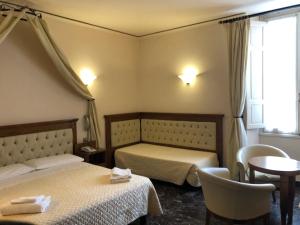 a hotel room with two beds and a table and chairs at Hotel Le Due Fontane in Florence