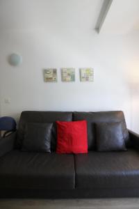 a black couch with a red pillow on it at Apartamento Labegain 5 in Sestao