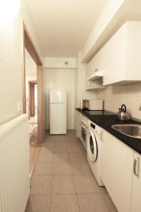 塞斯陶的住宿－Apartamento Labegain 5，厨房配有水槽和白色冰箱