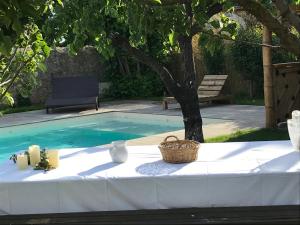 a table with a basket on it next to a swimming pool at La Closerie in Villeneuve-lès-Béziers
