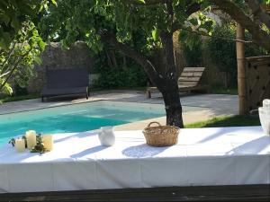 einen Tisch mit einem Korb neben einem Pool in der Unterkunft La Closerie in Villeneuve-lès-Béziers